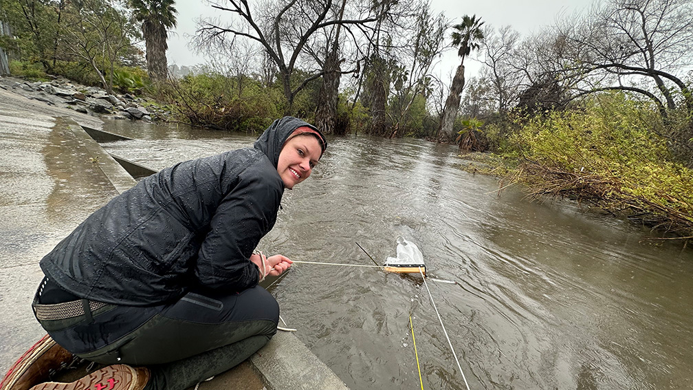 student at SD river captures trash with net